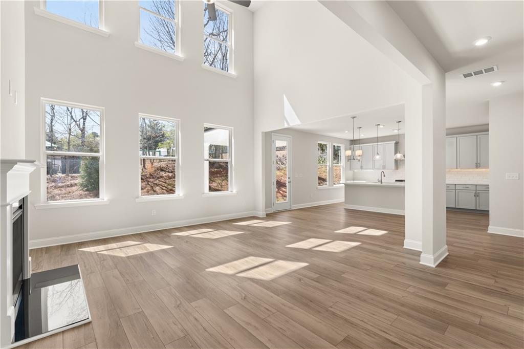 Two-story great room with fireplace and open kitchen in The Danbury C floor plan at Melody Lakeside Estates, Buford, GA.