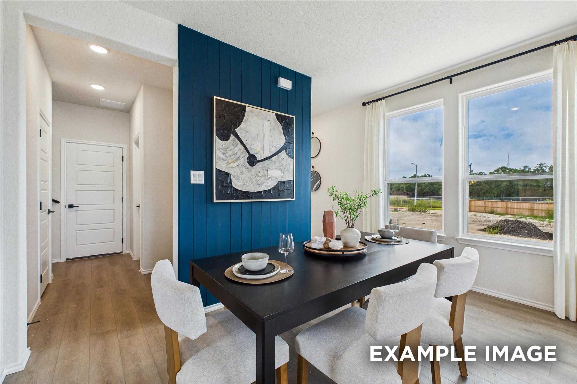 Elegant dining room with navy accent wall, abstract art, and window views in Davidson Homes The Florence C, San Antonio