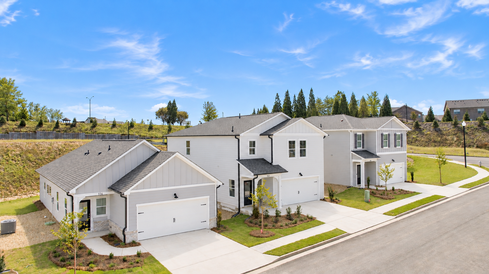 New homes at The Bluffs in Canton, Georgia by Davidson Homes, featuring gray siding, white garages, and landscaped front yards