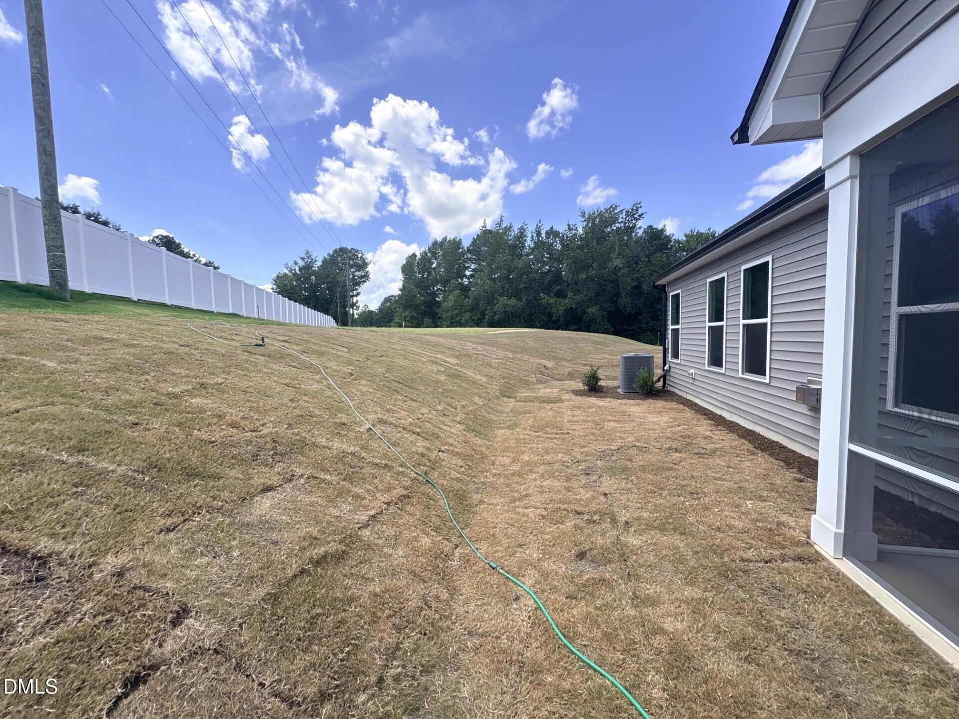 Spacious backyard with a white privacy fence at The Ash C floor plan in Woodland Crossing, Zebulon, North Carolina.