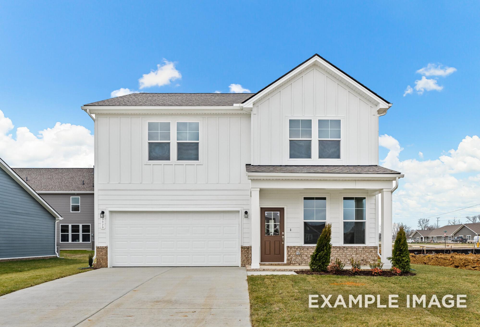 Two-story The Logan C home design with white board-and-batten siding, covered front porch, two-car garage, and landscaped yard in White House, TN