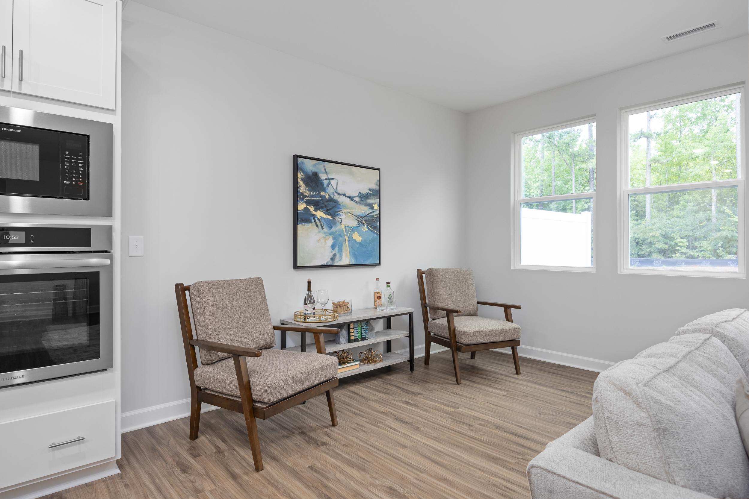 Bright living area in The Warren floor plan by Davidson Homes featuring modern decor, wood flooring, and built-in appliances.