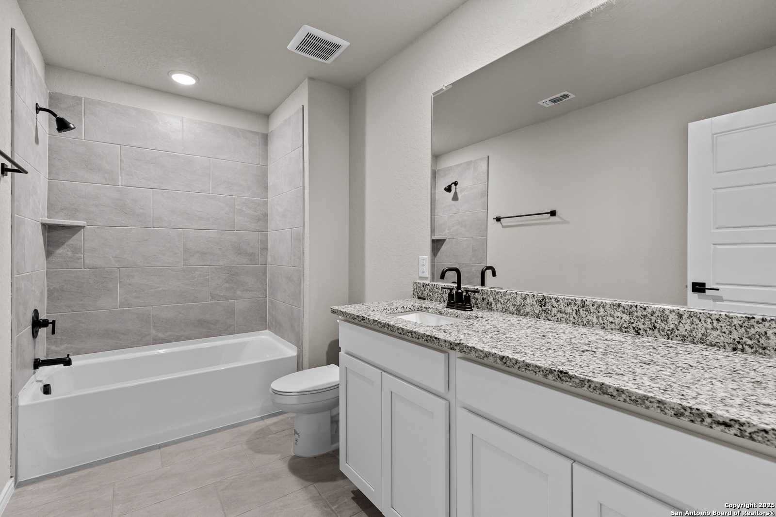 Modern master bathroom featuring freestanding tub, tiled walk-in shower, and quartz double vanity in Davidson Homes The Murray I, San Antonio
