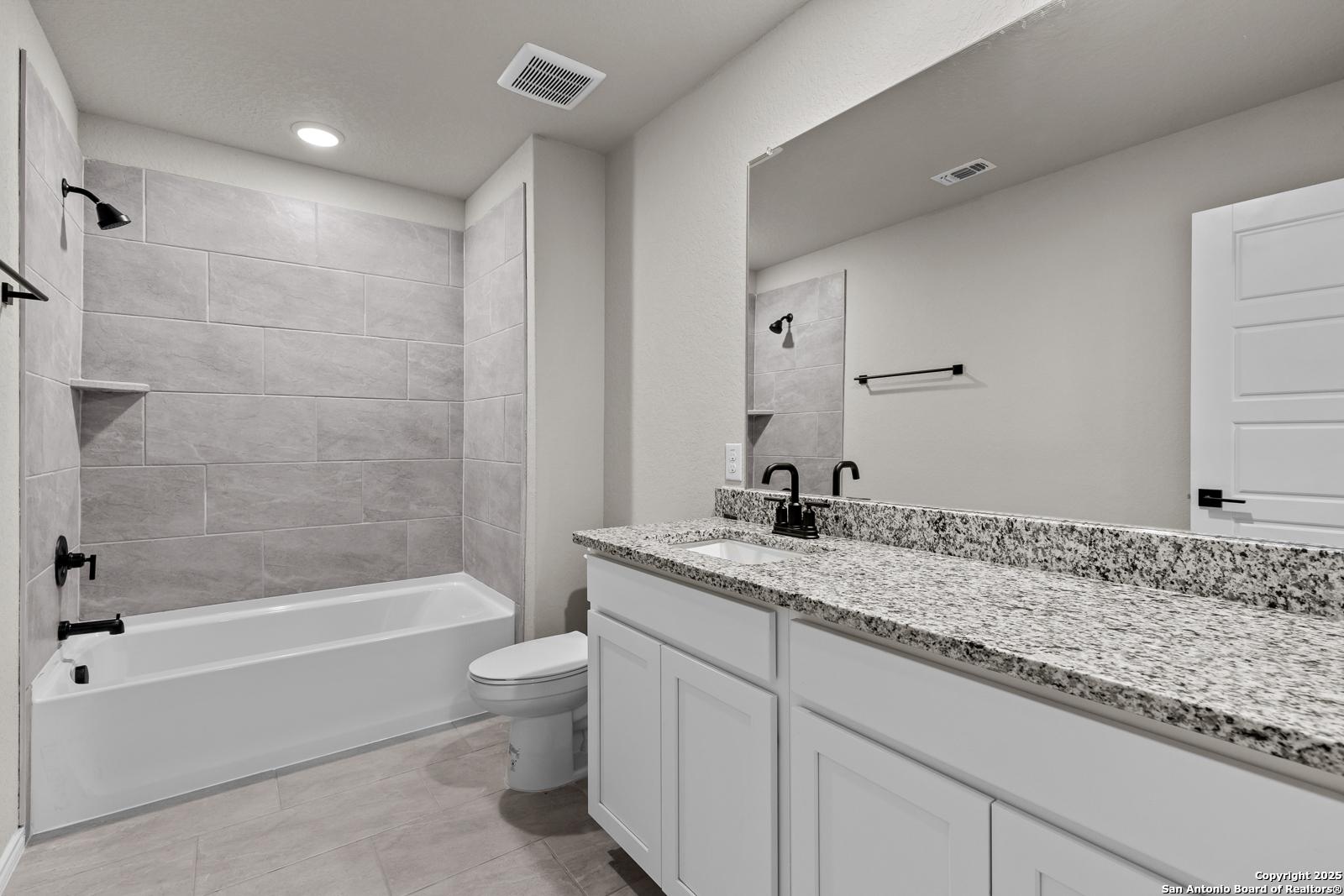 Modern master bathroom featuring freestanding tub, tiled walk-in shower, and quartz double vanity in Davidson Homes The Murray I, San Antonio