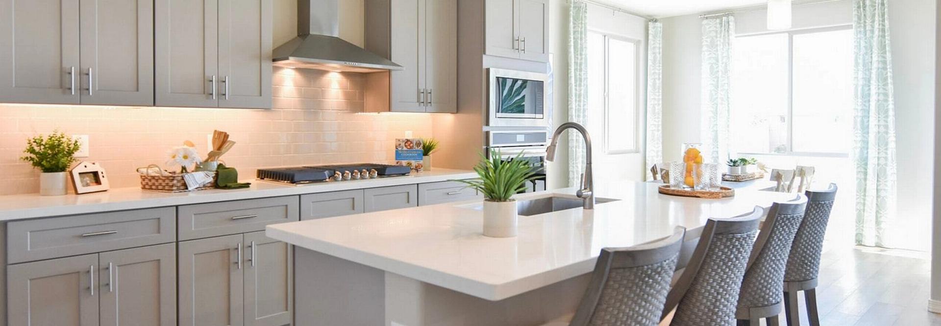 Contemporary kitchen with gray shaker cabinets, white quartz island, bar stools, and stainless appliances at North Ridge Pronghorn Ranch in Prescott Valley AZ