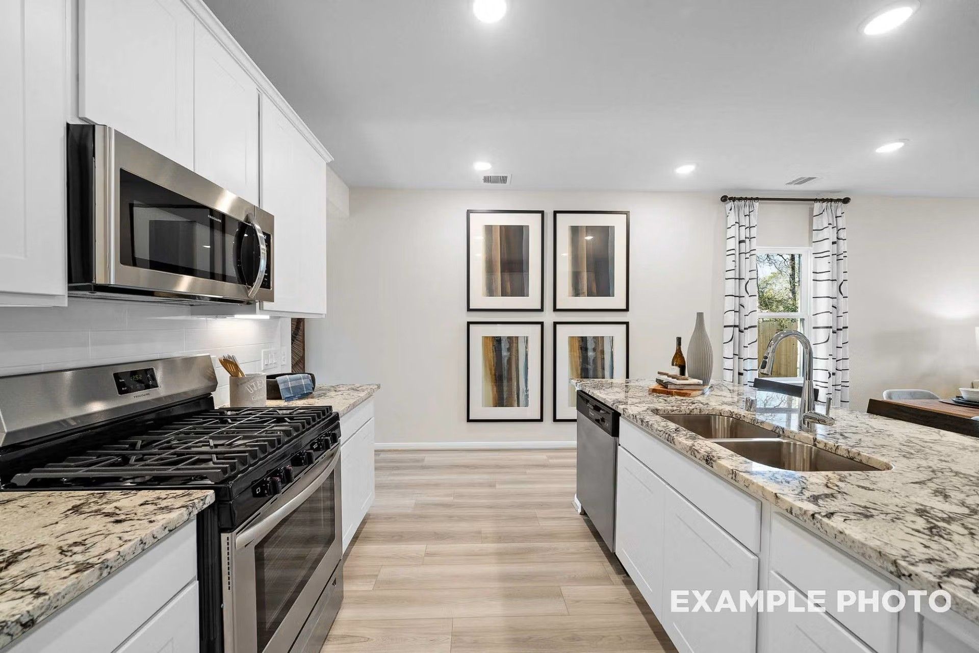 Modern kitchen with white cabinets, granite countertops, and stainless appliances in San Marcos E floor plan, Heartland, TX.