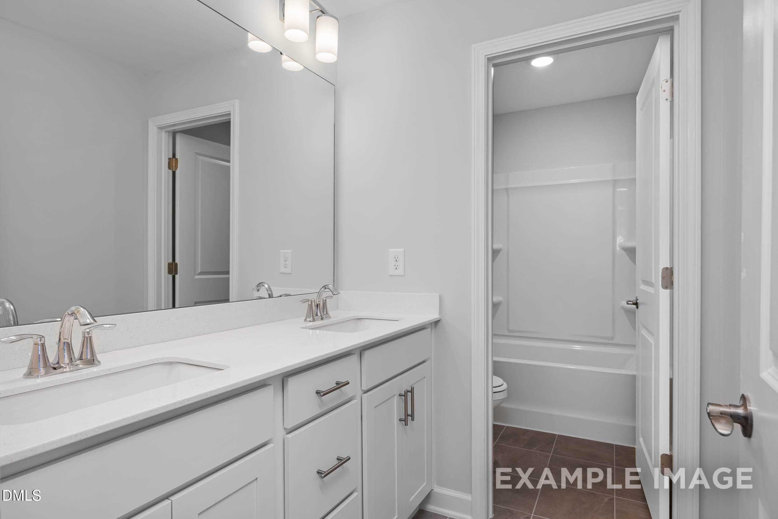 Modern master bathroom with double vanity, soaking tub, and white cabinetry in Davidson Homes The Ash B, Lillington, NC