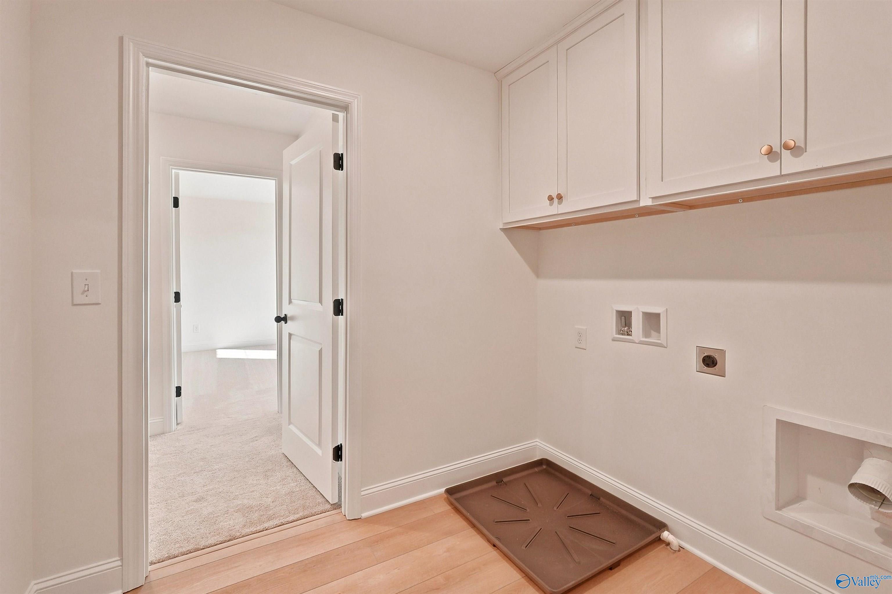 Laundry room with white cabinets and washer-dryer hookups in The Chelsea C floor plan at Creek Grove in New Market, Alabama.