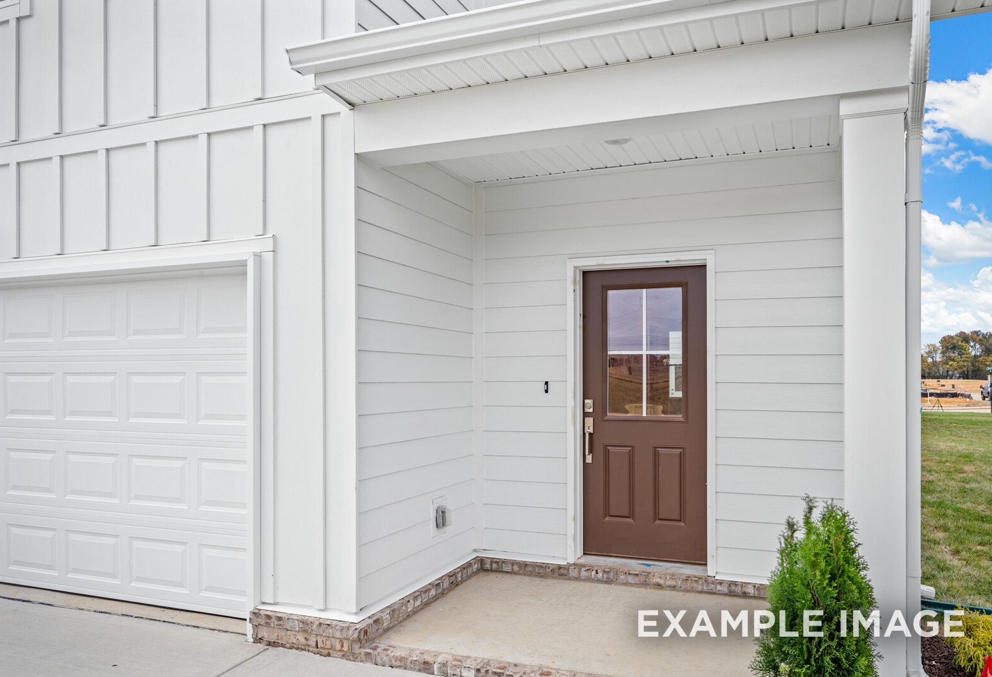 Front elevation of Grayson A 2-story home with white board-and-batten siding, covered porch, brown glass door, and 2-car garage