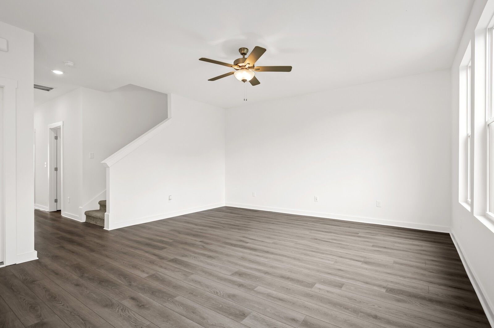 Bright, open-concept living area with wood-style flooring in The Logan C floor plan at Calista Farms, White House, TN.