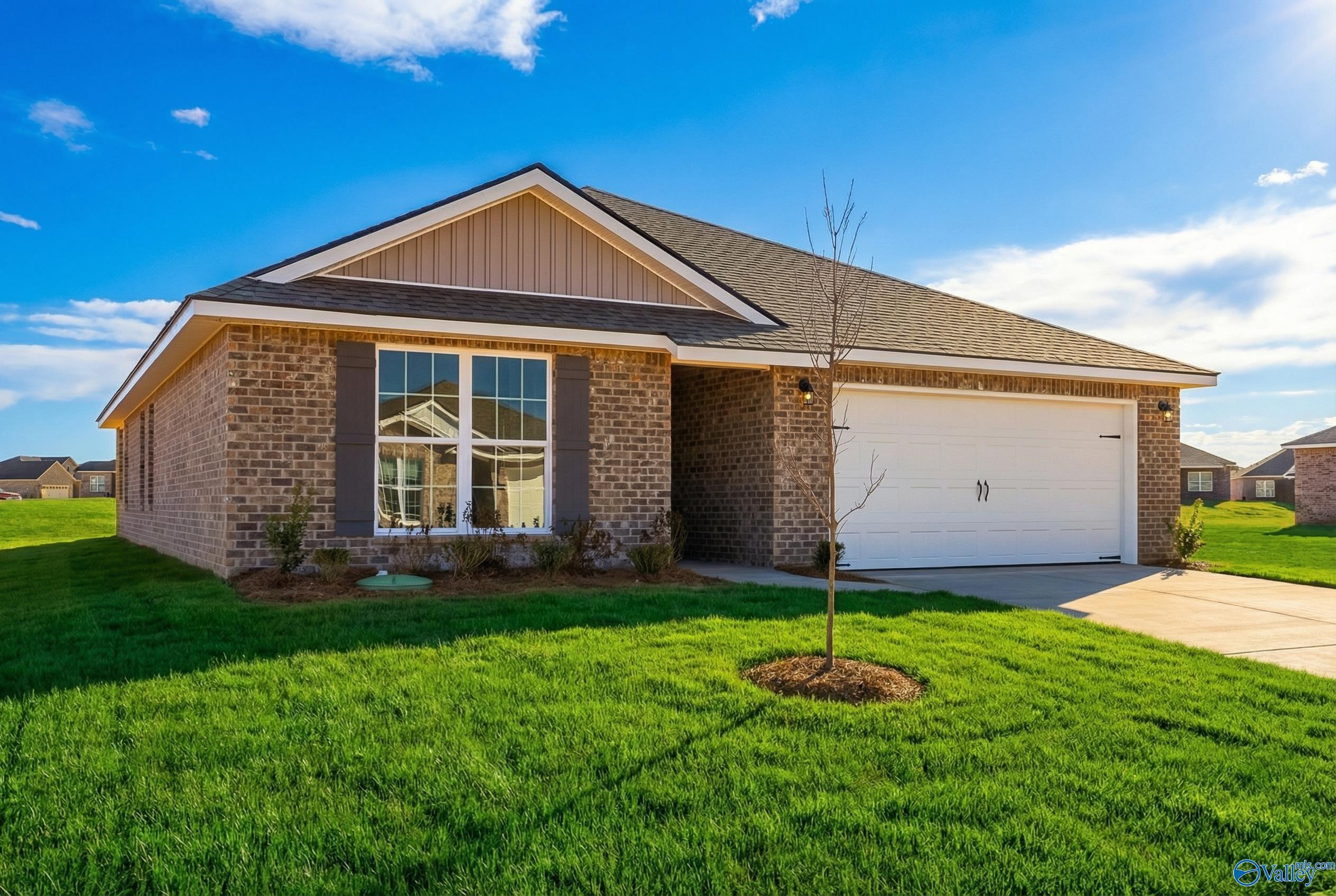 Brick 1-story home with 2-car garage, large windows, and lush green lawn in Heritage Lakes, New Market, Alabama - Davidson Homes The Franklin