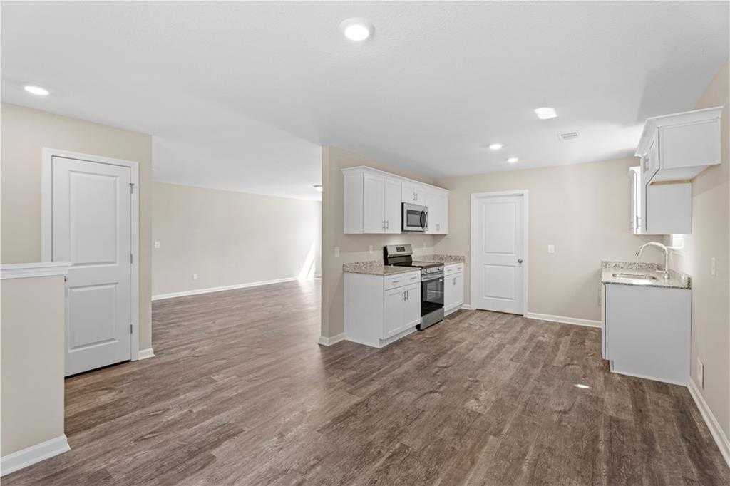 Modern kitchen with white cabinets, stainless steel appliances, and open layout in Davidson Homes The Washington, Phenix City, AL