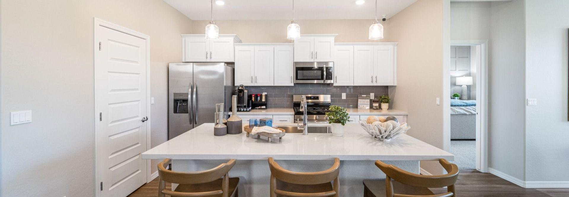 Modern kitchen with quartz island, gray cabinets, stainless appliances and pendant lights at Vineyards at Cottonwood in Cottonwood AZ
