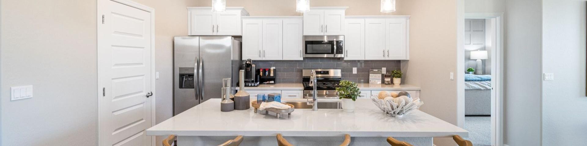 Modern kitchen with quartz island, gray cabinets, stainless appliances and pendant lights at Vineyards at Cottonwood in Cottonwood AZ