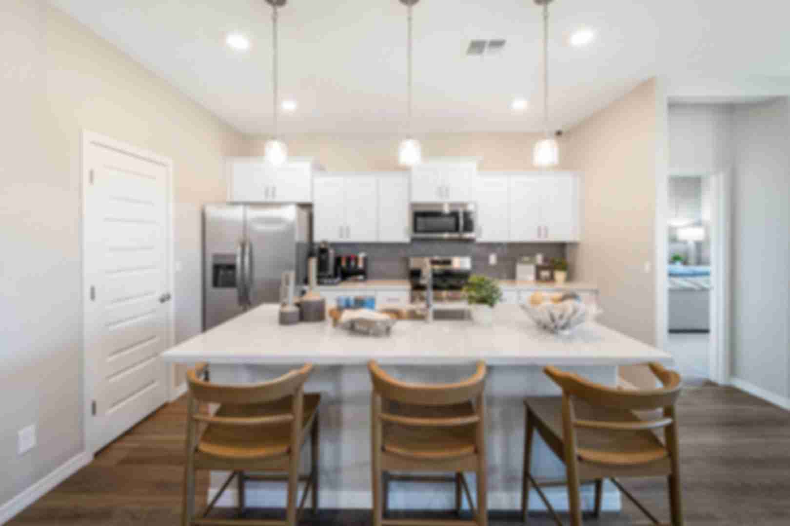 Modern kitchen with quartz island, gray cabinets, stainless appliances and pendant lights at Vineyards at Cottonwood in Cottonwood AZ