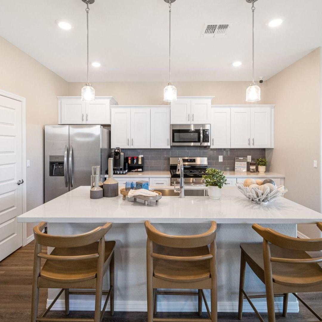 Modern kitchen with quartz island, gray cabinets, stainless appliances and pendant lights at Vineyards at Cottonwood in Cottonwood AZ