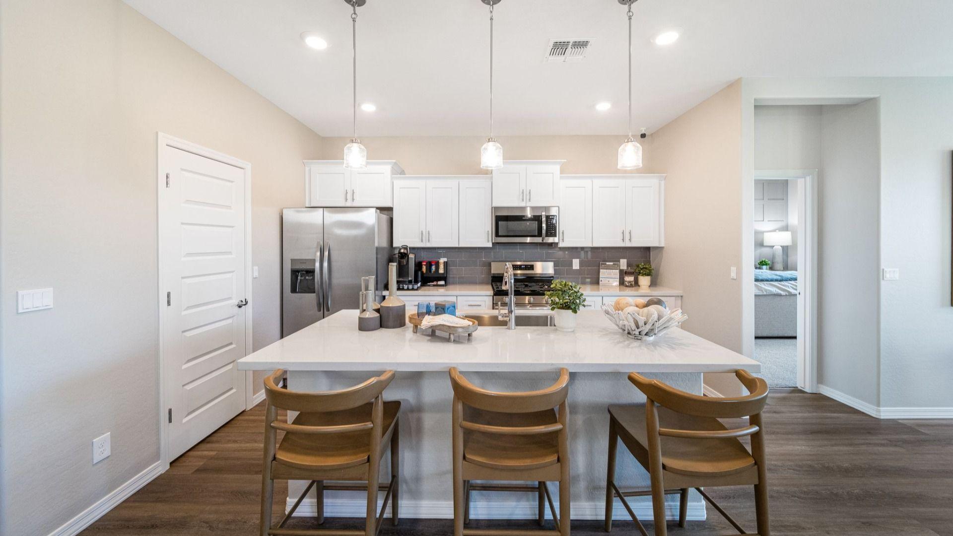 Modern kitchen with quartz island, gray cabinets, stainless appliances and pendant lights at Vineyards at Cottonwood in Cottonwood AZ