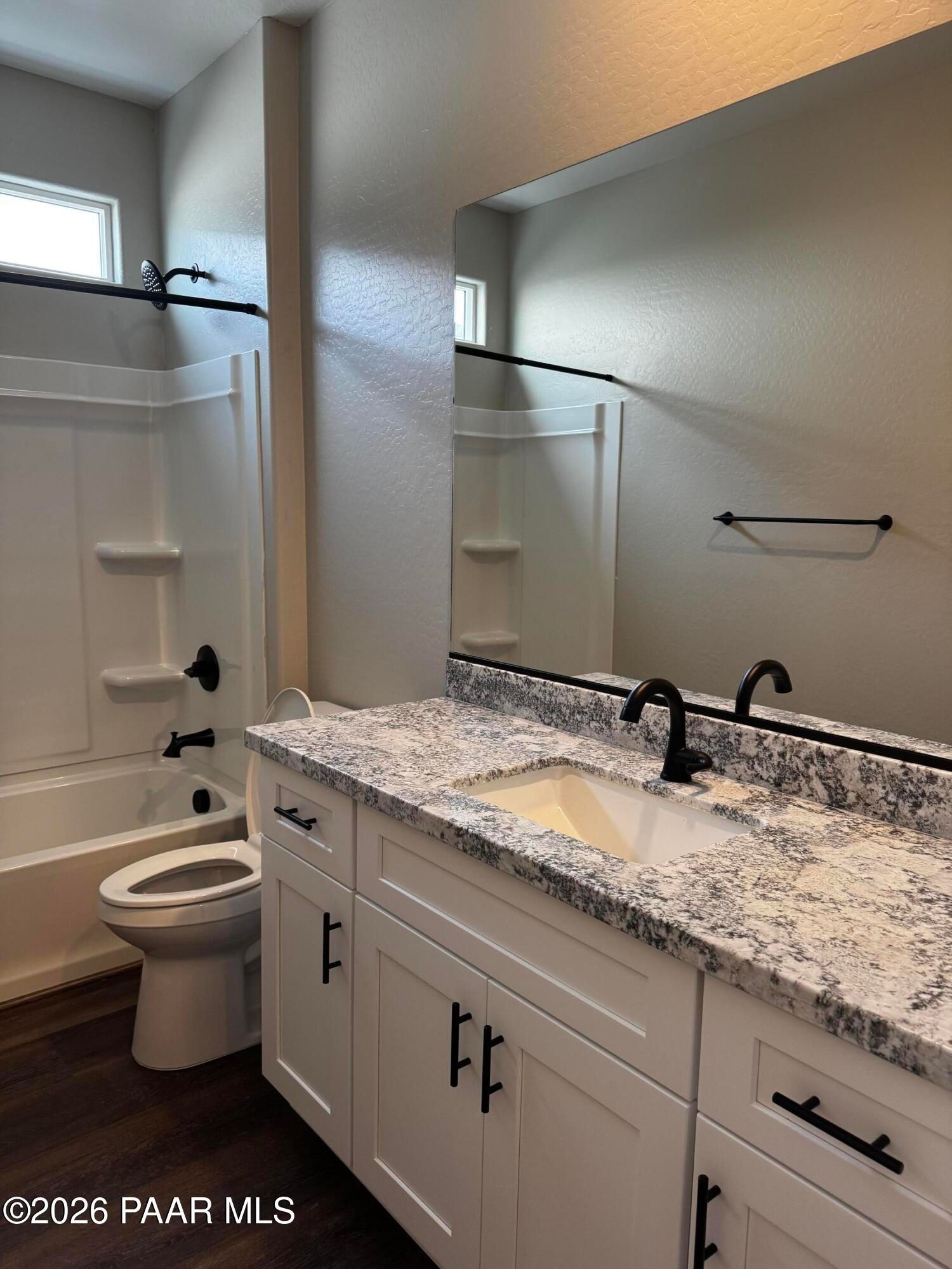 Modern bathroom with white shaker cabinets, quartz countertop, soaking tub, and black fixtures in Durango II B, Prescott AZ