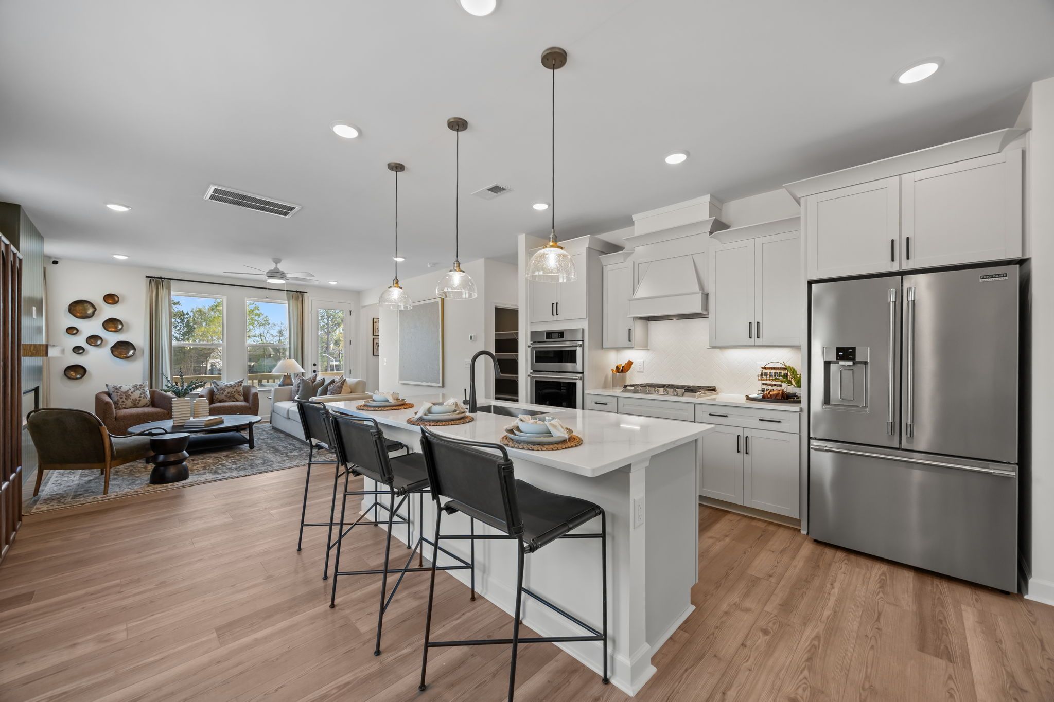Spacious open-concept kitchen at Camden Park in Knightdale NC with white shaker cabinets, quartz island, pendant lights, and stainless steel appliances