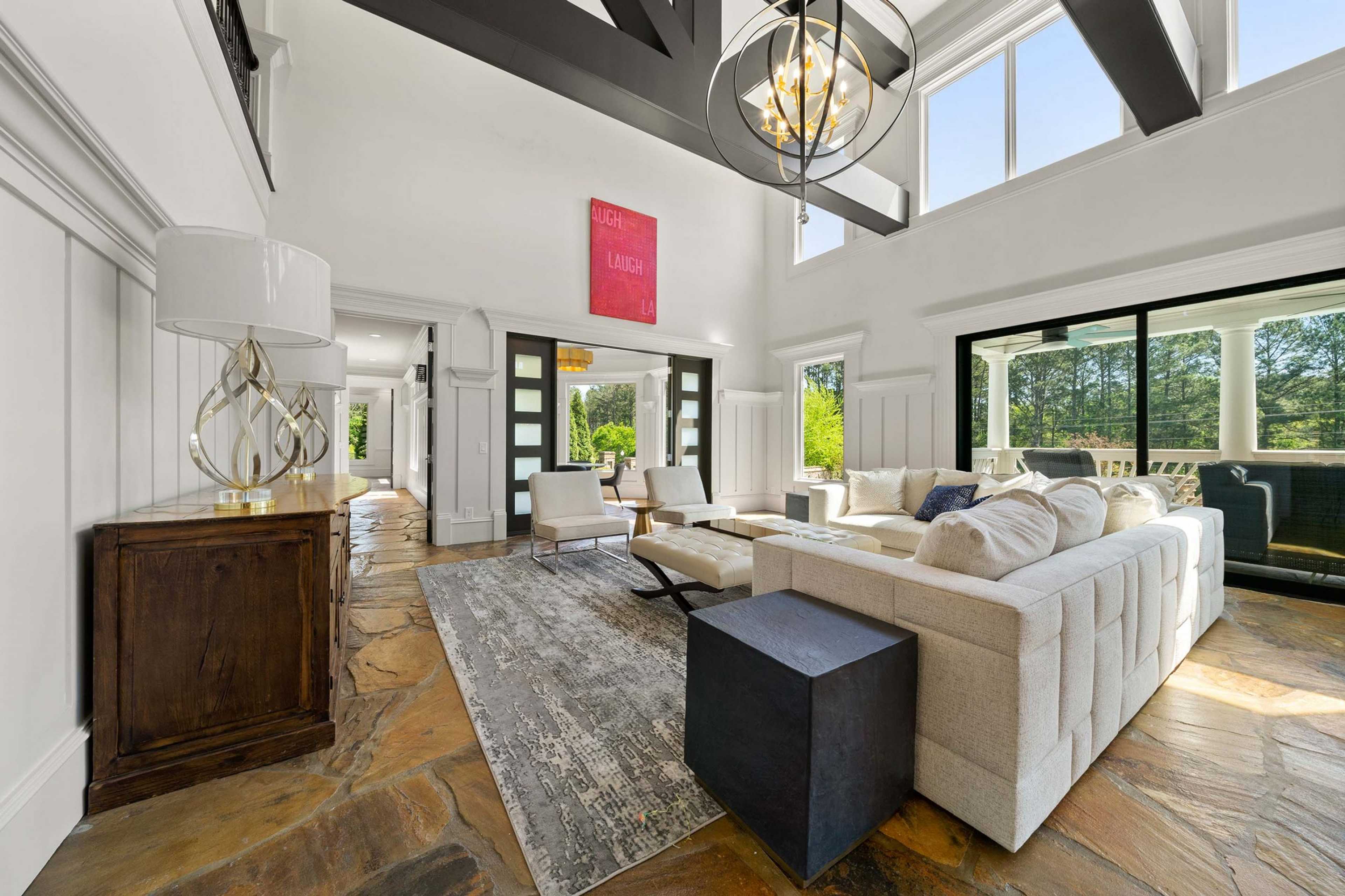 Spacious open-concept living room at Mountainbrook in Cartersville Georgia with shiplap walls, chandelier, cream sofa, and large windows