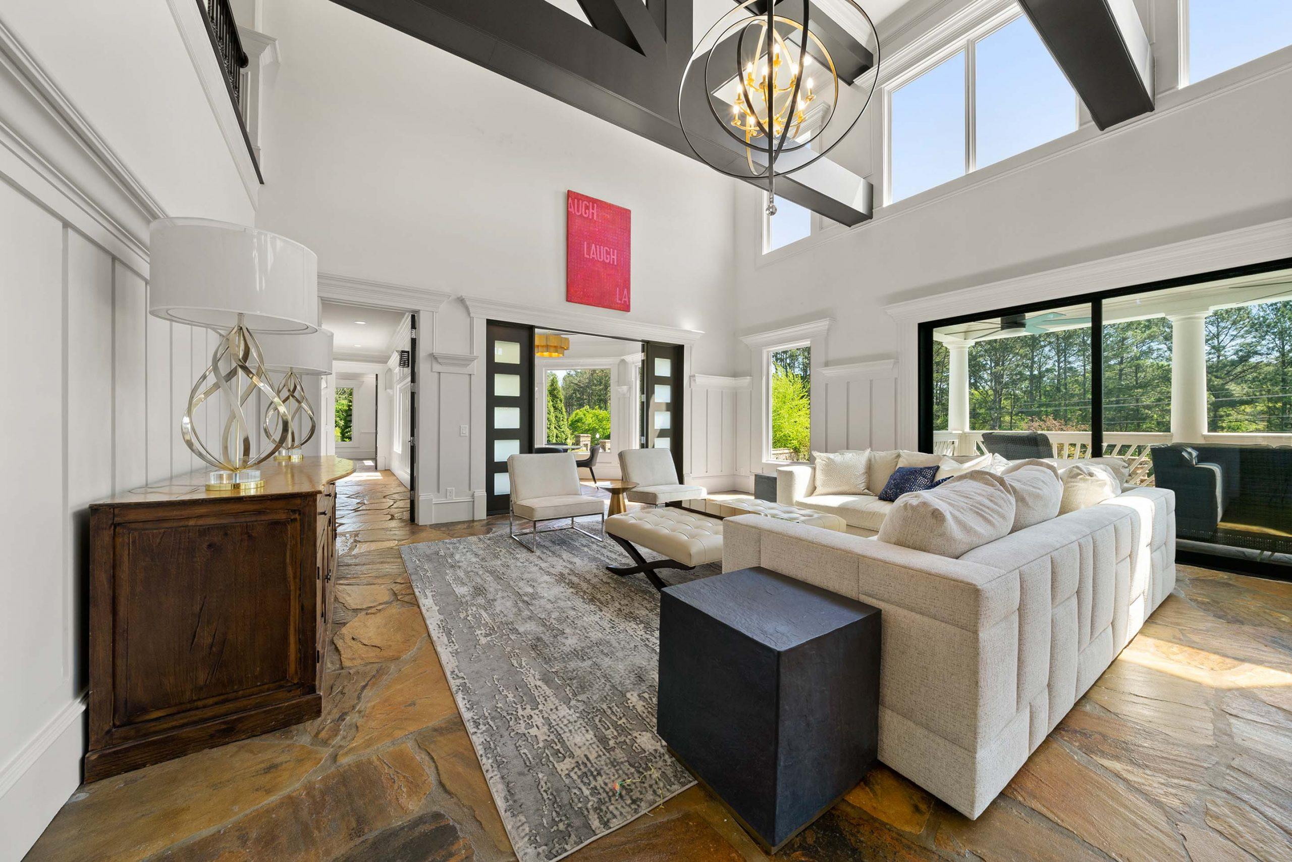 Spacious open-concept living room at Mountainbrook in Cartersville Georgia with shiplap walls, chandelier, cream sofa, and large windows