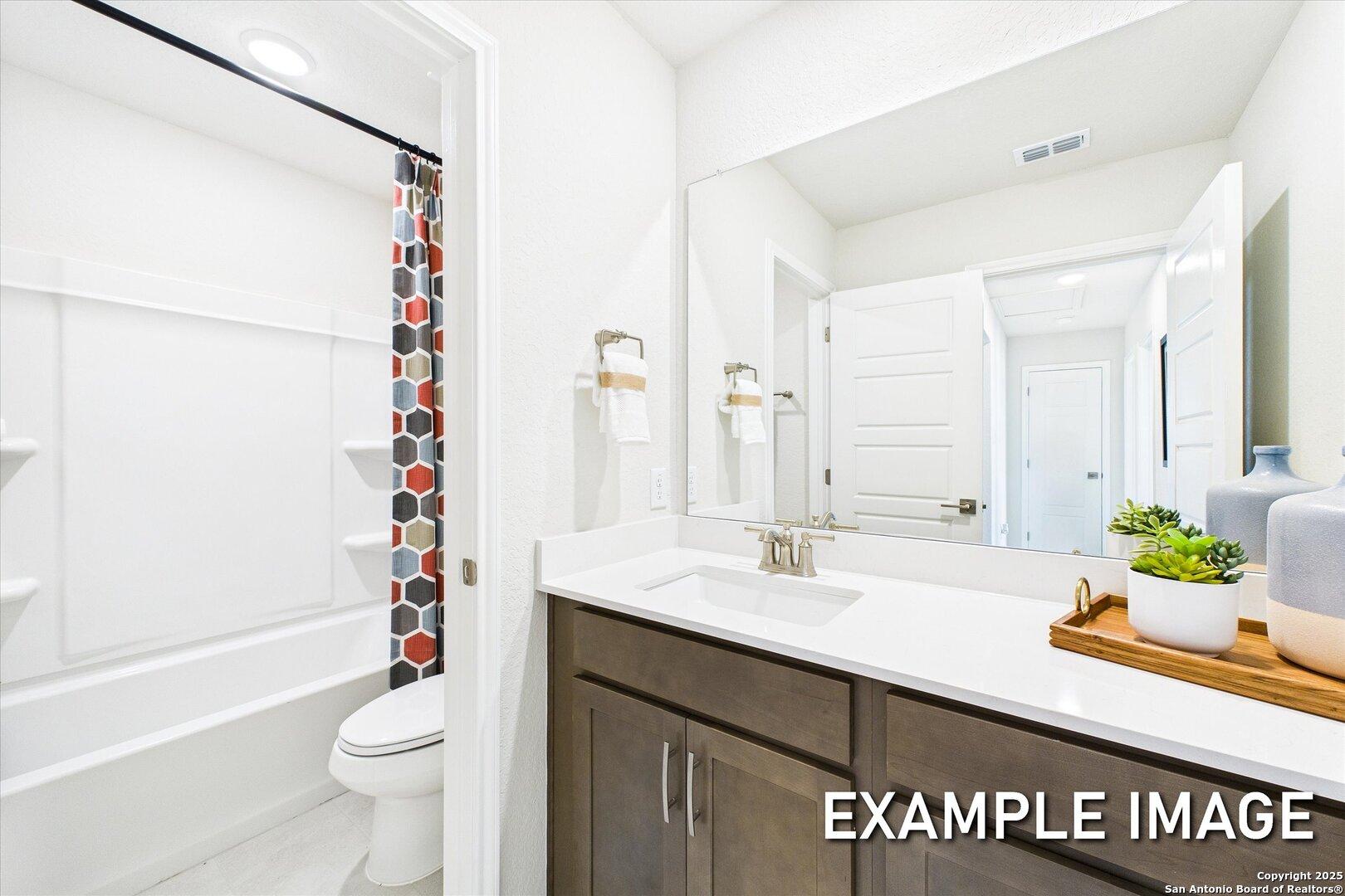 Modern guest bathroom featuring white subway tile shower, geometric curtain, and shaker-style vanity in Davidson Homes The Brazos C, Agave, San Antonio