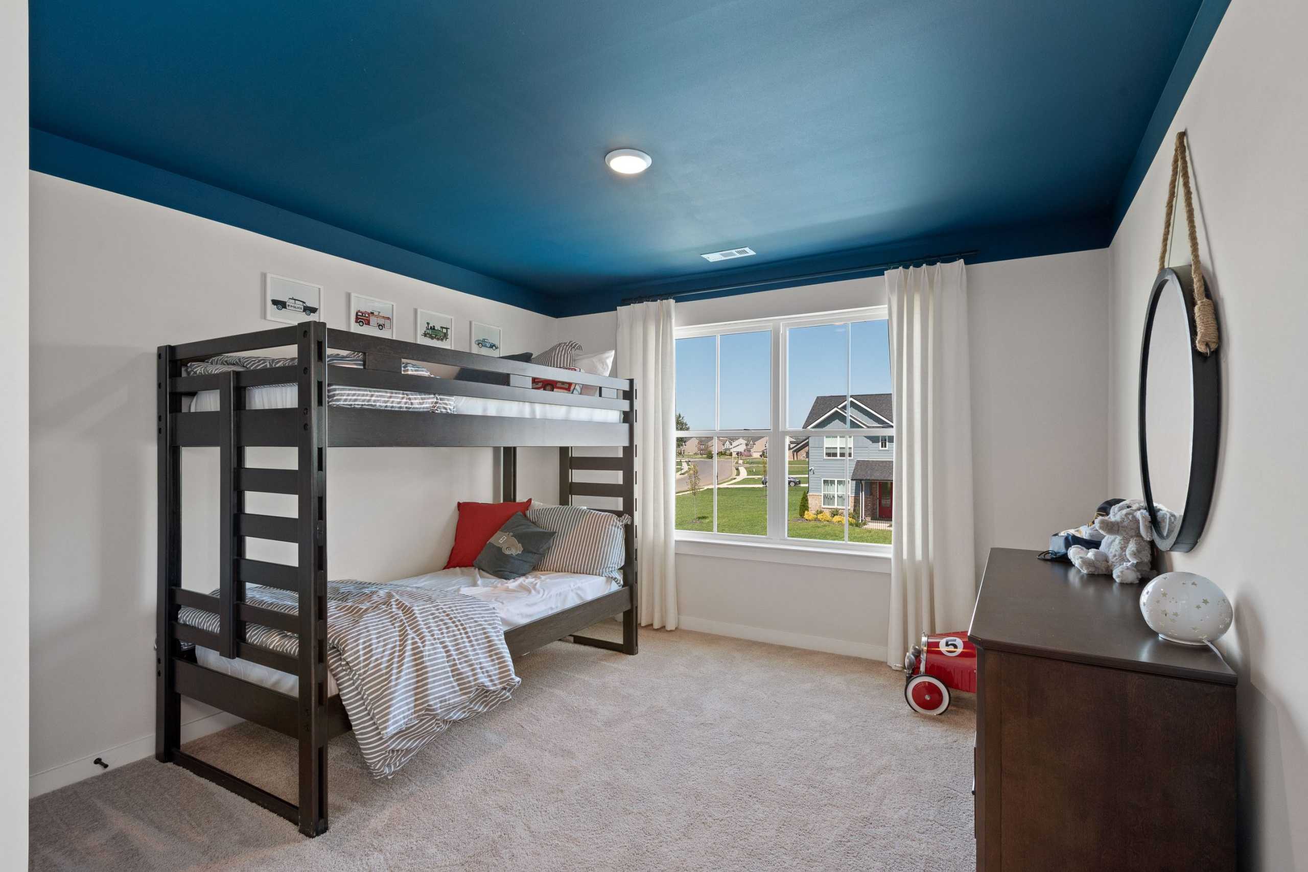 Boys' bedroom at Rivers Edge in Murfreesboro TN with navy blue ceiling, black bunk bed, toys and neighborhood view