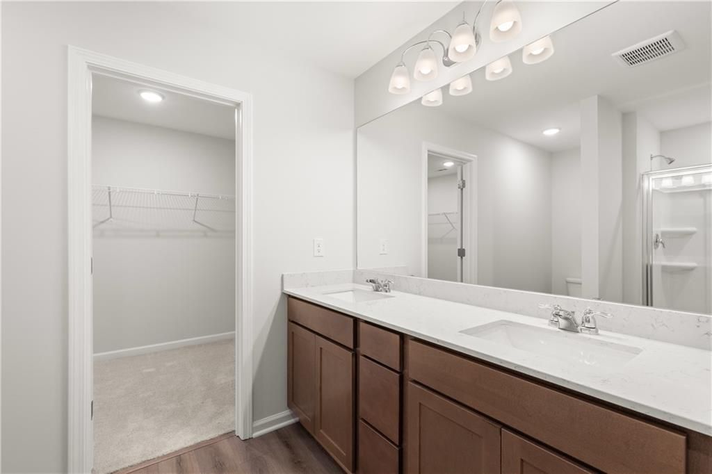Modern master bathroom with dual-sink vanity and walk-in closet in The Sinclair B floor plan at Cedar Farms, Winder, GA.