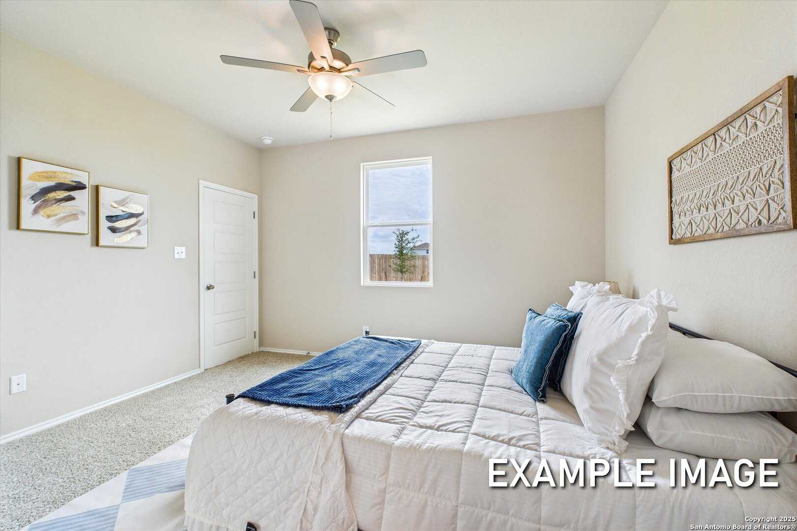 Cozy secondary bedroom with ceiling fan, beige walls, framed art, and plush queen bed in Davidson Homes The Comal B, Agave, San Antonio