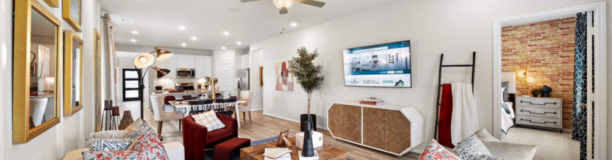 Modern open-concept living room in new Lavon home with beige sofas, wooden coffee table, large TV, plants, and recessed lighting