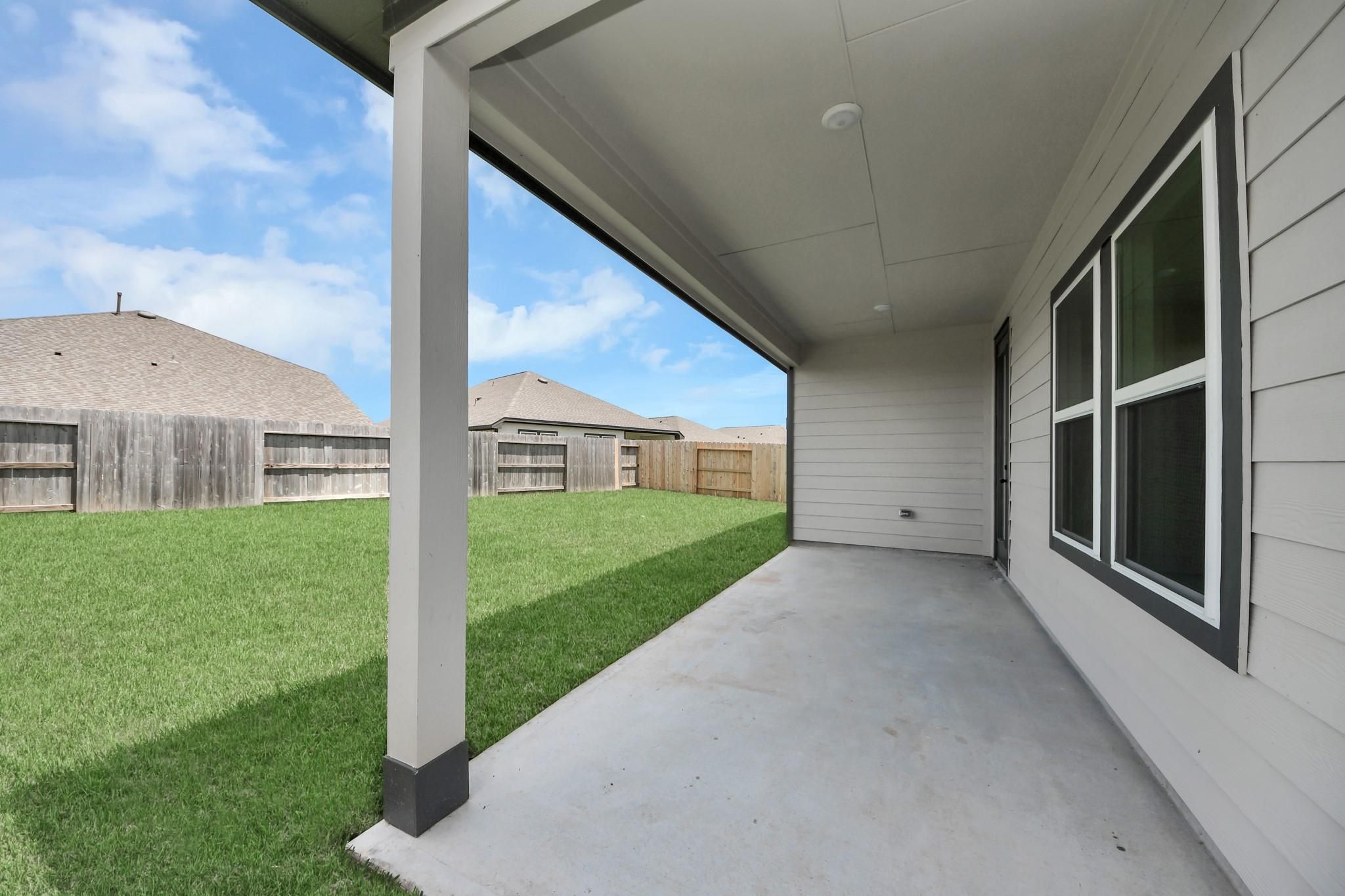 Covered back patio and spacious private backyard of The Laguna C floor plan by Davidson Homes in Sunterra, Katy, Texas.