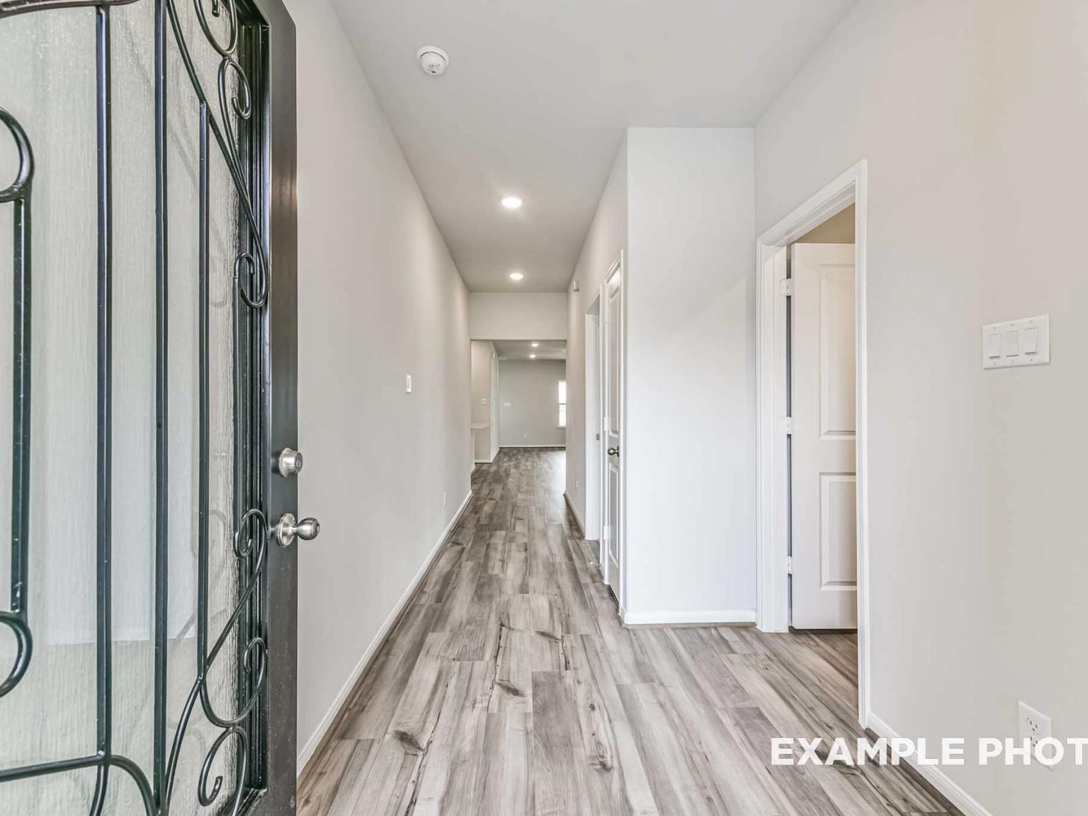 Bright entryway with wood-look flooring in The Laguna C floor plan by Davidson Homes in River Ranch Meadows, Dayton, Texas.