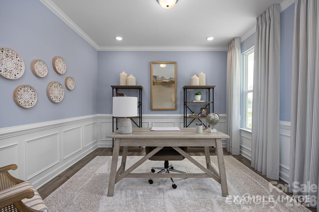 Bright home office with wainscoting and wooden desk in The Magnolia A floor plan by Davidson Homes in Windgate, NC.