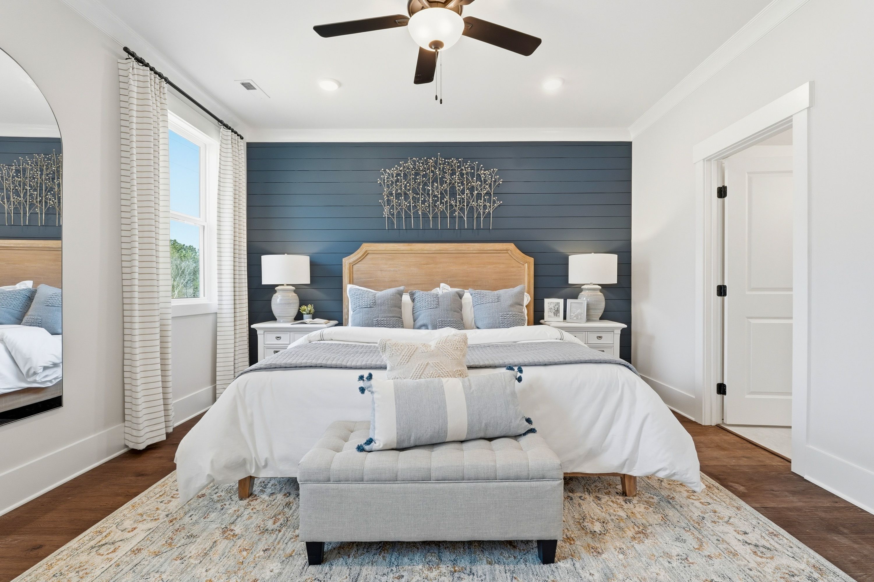 Cozy primary bedroom at Noble Ridge in Cullman Alabama with king bed, navy shiplap accent wall, ceiling fan