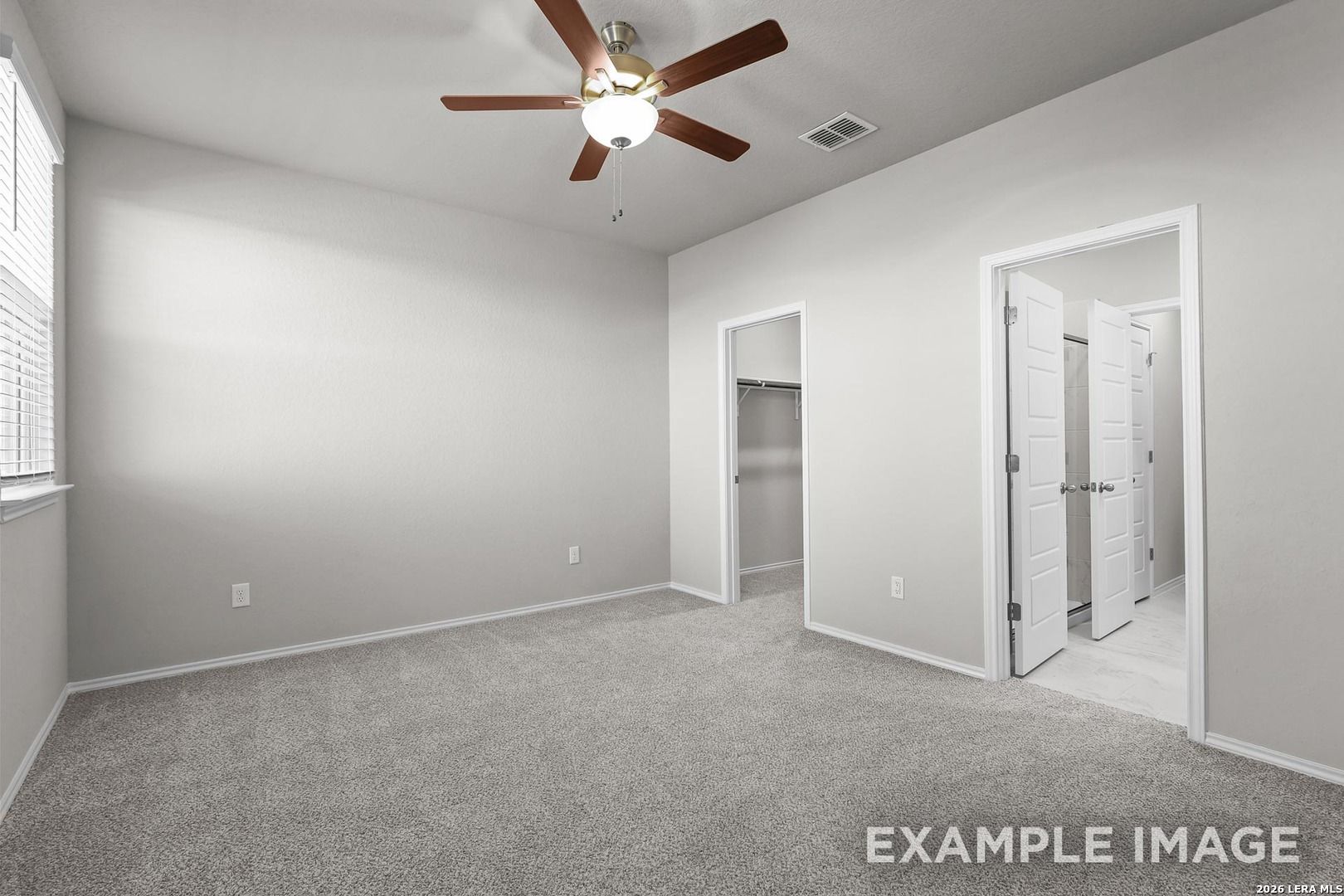 Spacious bedroom with ceiling fan, carpet flooring, walk-in closet, and adjacent bath in Davidson Homes The Colorado D, San Antonio
