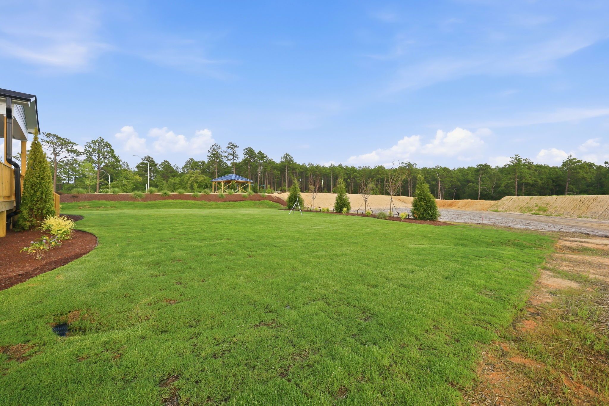 Spacious backyard of The Beech home in Belmont, NC featuring lush green lawn and community gazebo views.