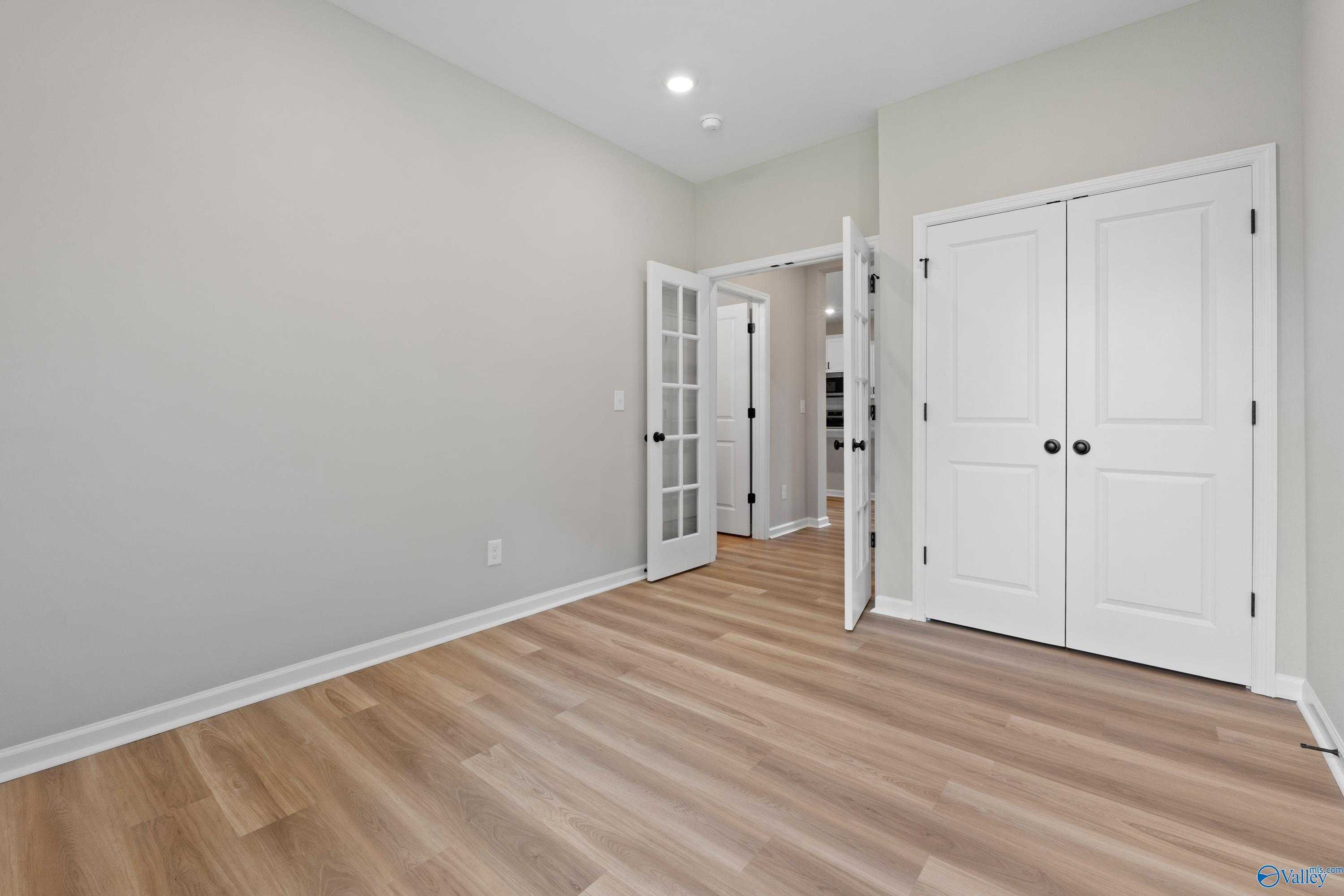 Bright study with open French doors, white double closet, hardwood floors in Evermore Homes The Nantucket, Madison AL