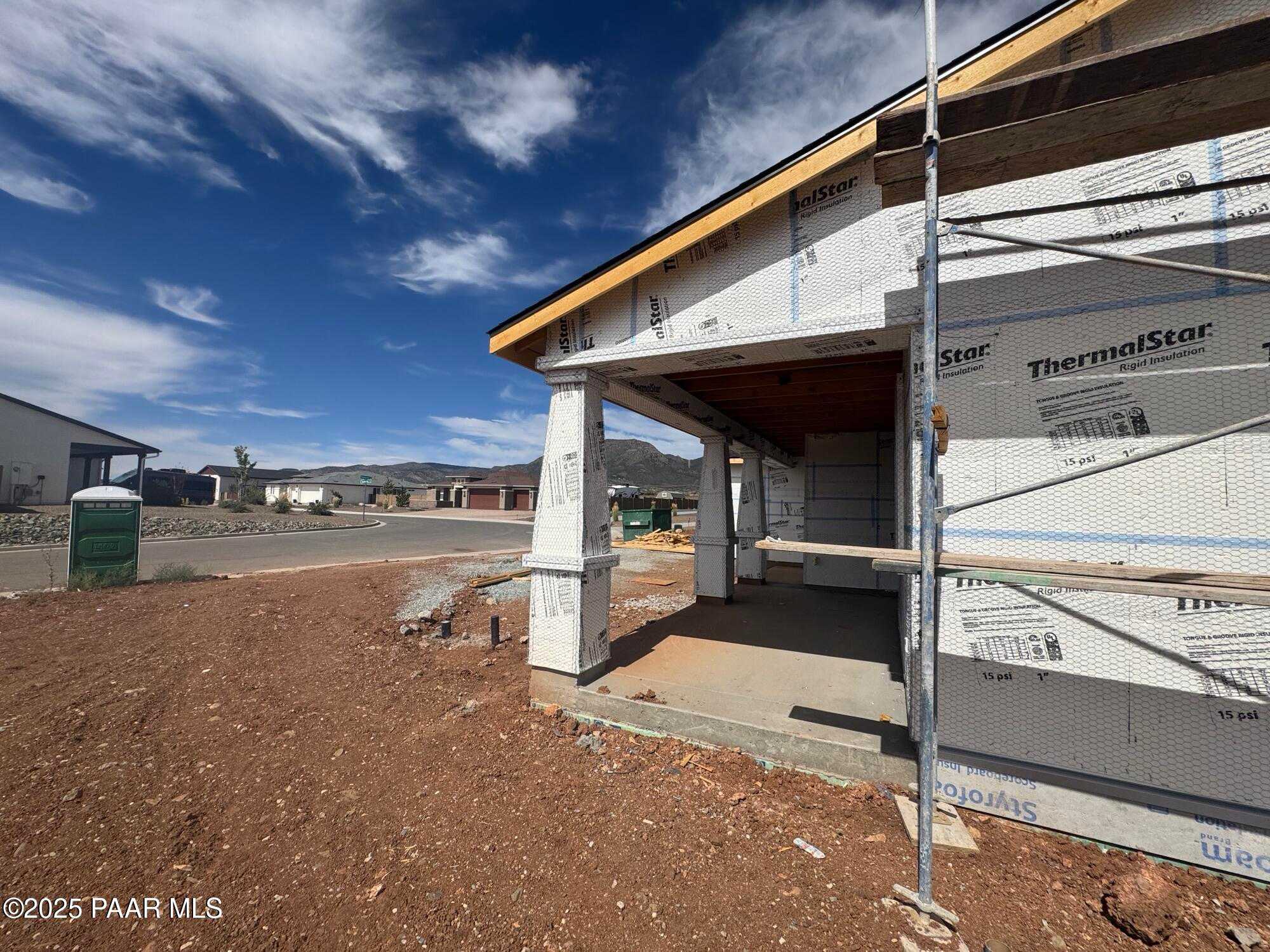 Under-construction single-story home exterior with covered entry, scaffolding, and Thermostar sheathing in Morningstar, Prescott Valley, Arizona