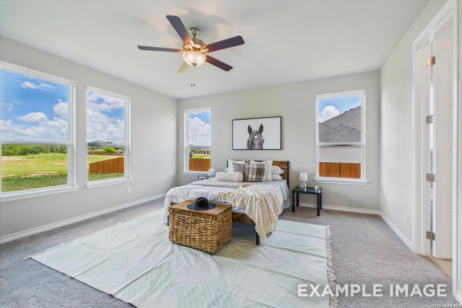 Bright, spacious secondary bedroom with large windows in The Foster F floor plan at Potranco Oaks, Castroville, Texas.