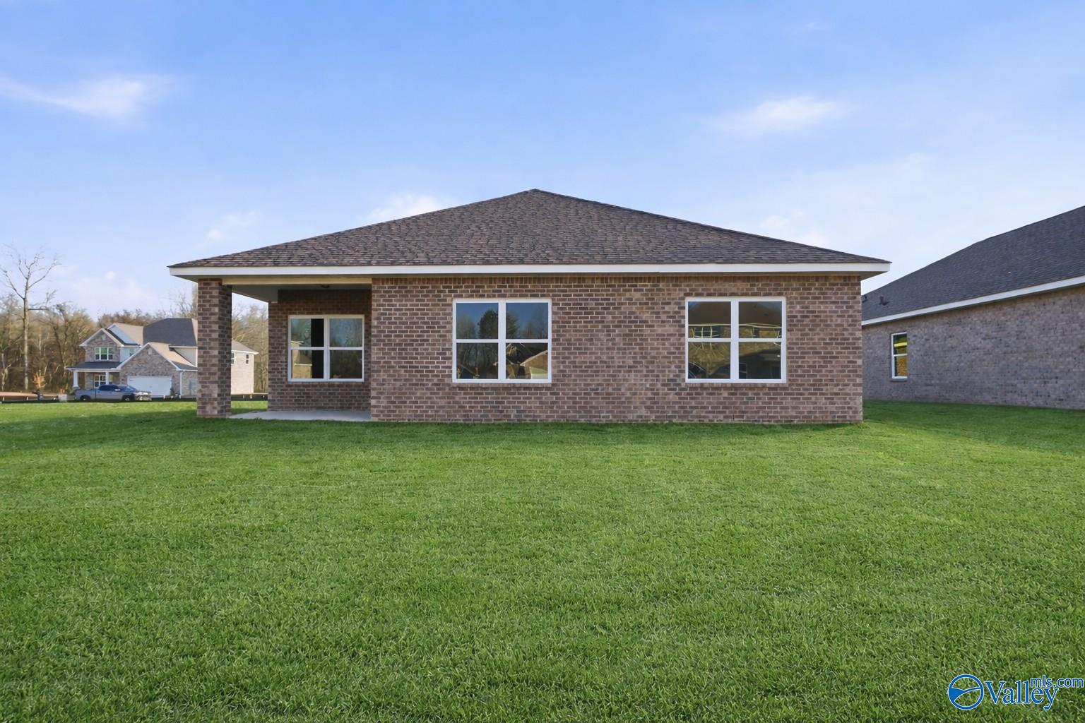 Brick single-story Daphne C home with covered porch, large windows, and lush green lawn in Ricketts Farm, Athens, Alabama