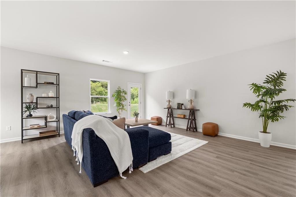 Bright, modern living room with blue sectional in The Sinclair B floor plan by Davidson Homes in Cedar Farms, Winder, GA.