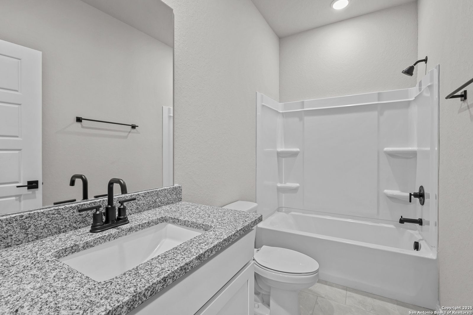 Elegant master bathroom with granite vanity, soaking tub, and shower in Davidson Homes The Daphne K, San Antonio, Texas