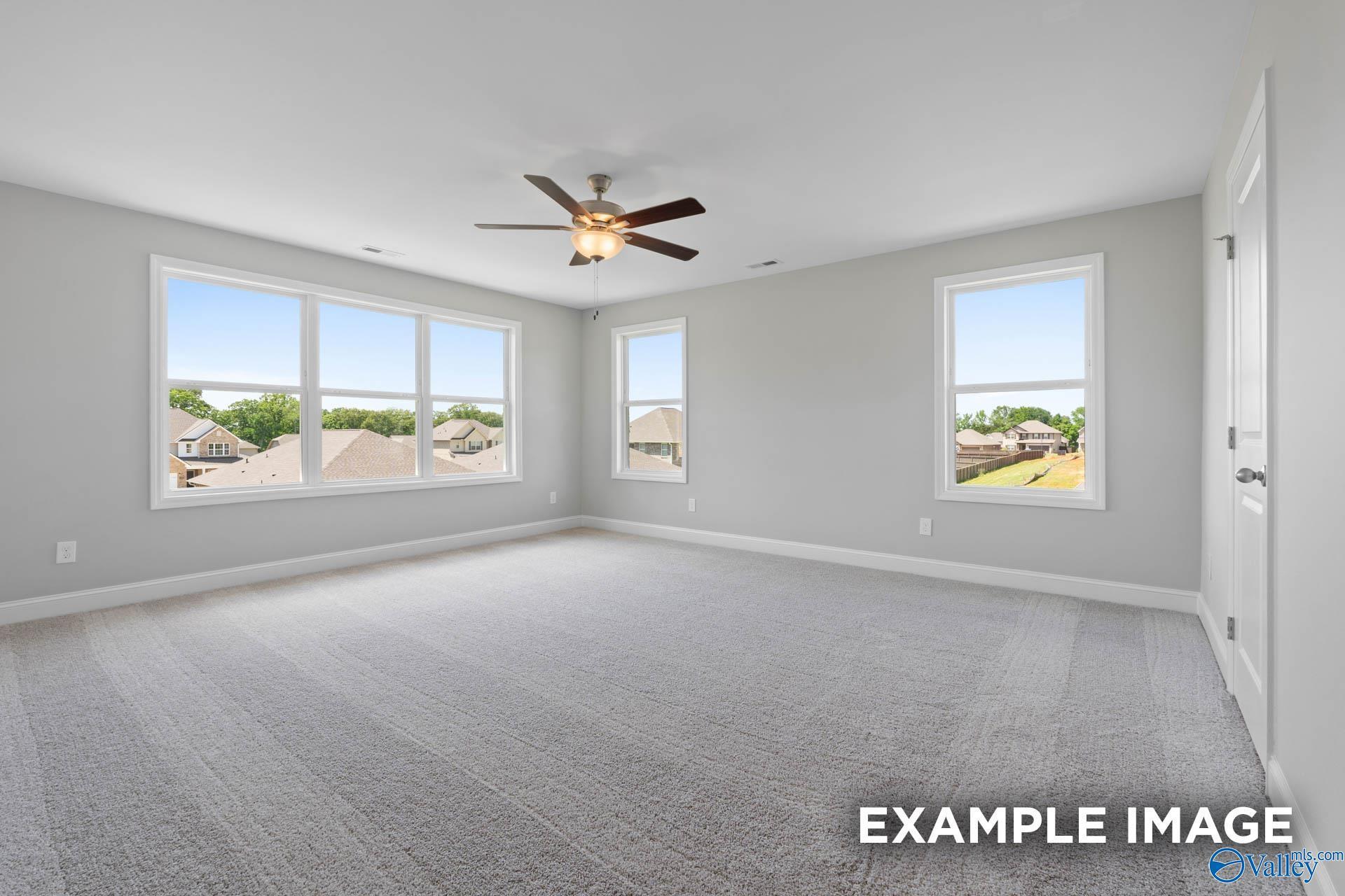Spacious, light-filled bedroom with plush carpet and ceiling fan in The Chelsea A floor plan, Walker's Hill, Meridianville.