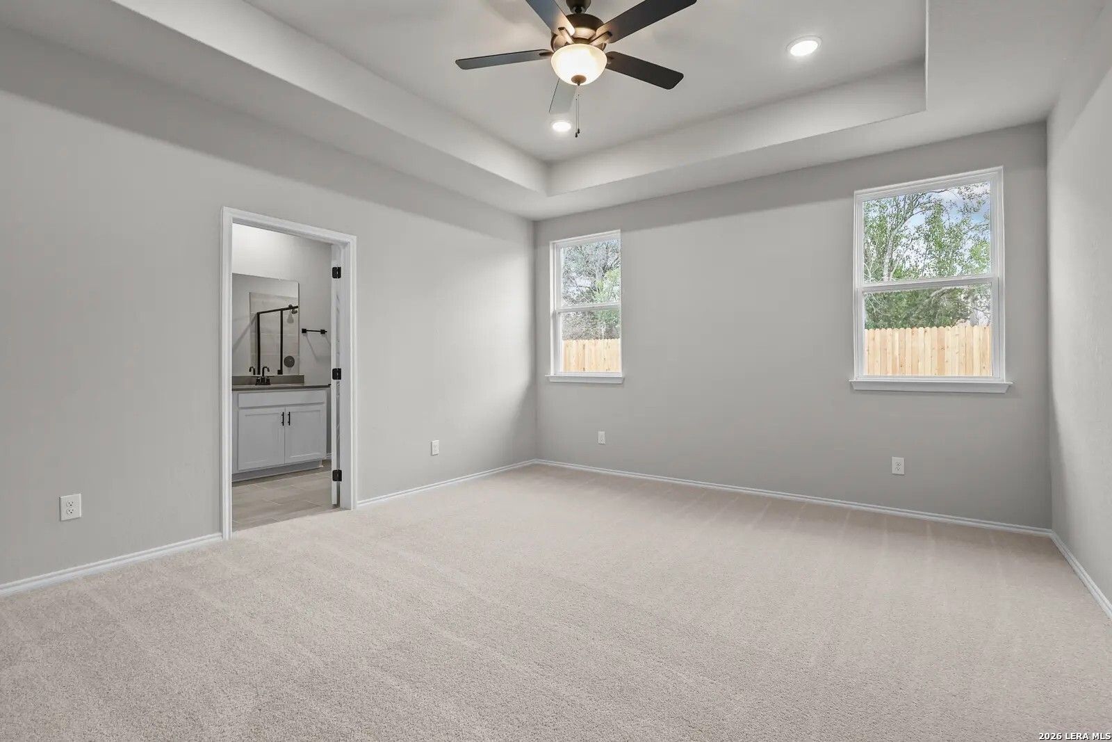 Spacious primary bedroom with tray ceiling and en-suite bath in The Glenwood E floor plan, Comanche Ridge, San Antonio.