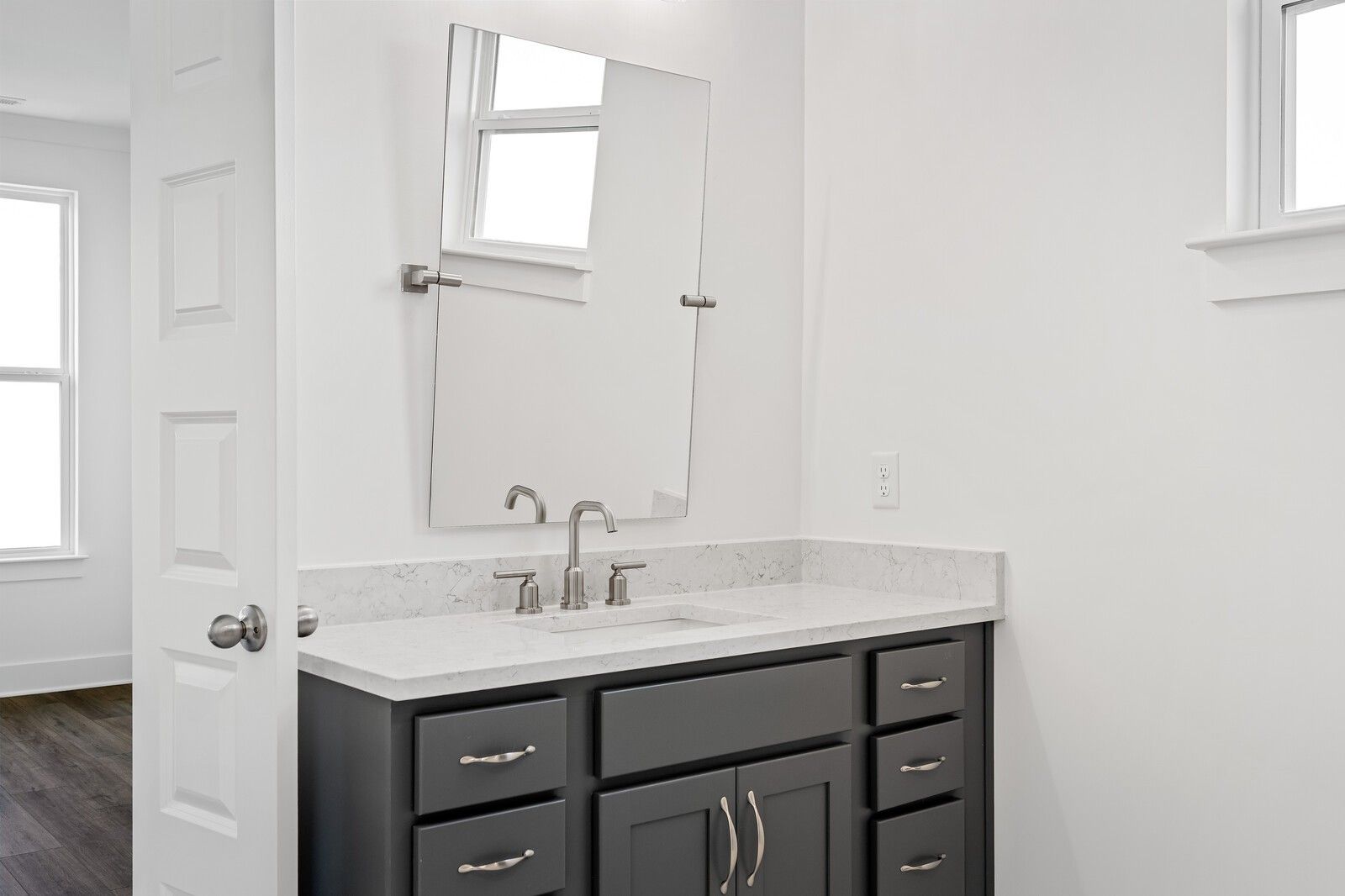 Modern gray double vanity with white quartz countertop, brushed nickel faucet, and large mirror in The Hawkins bathroom, Murfreesboro, TN