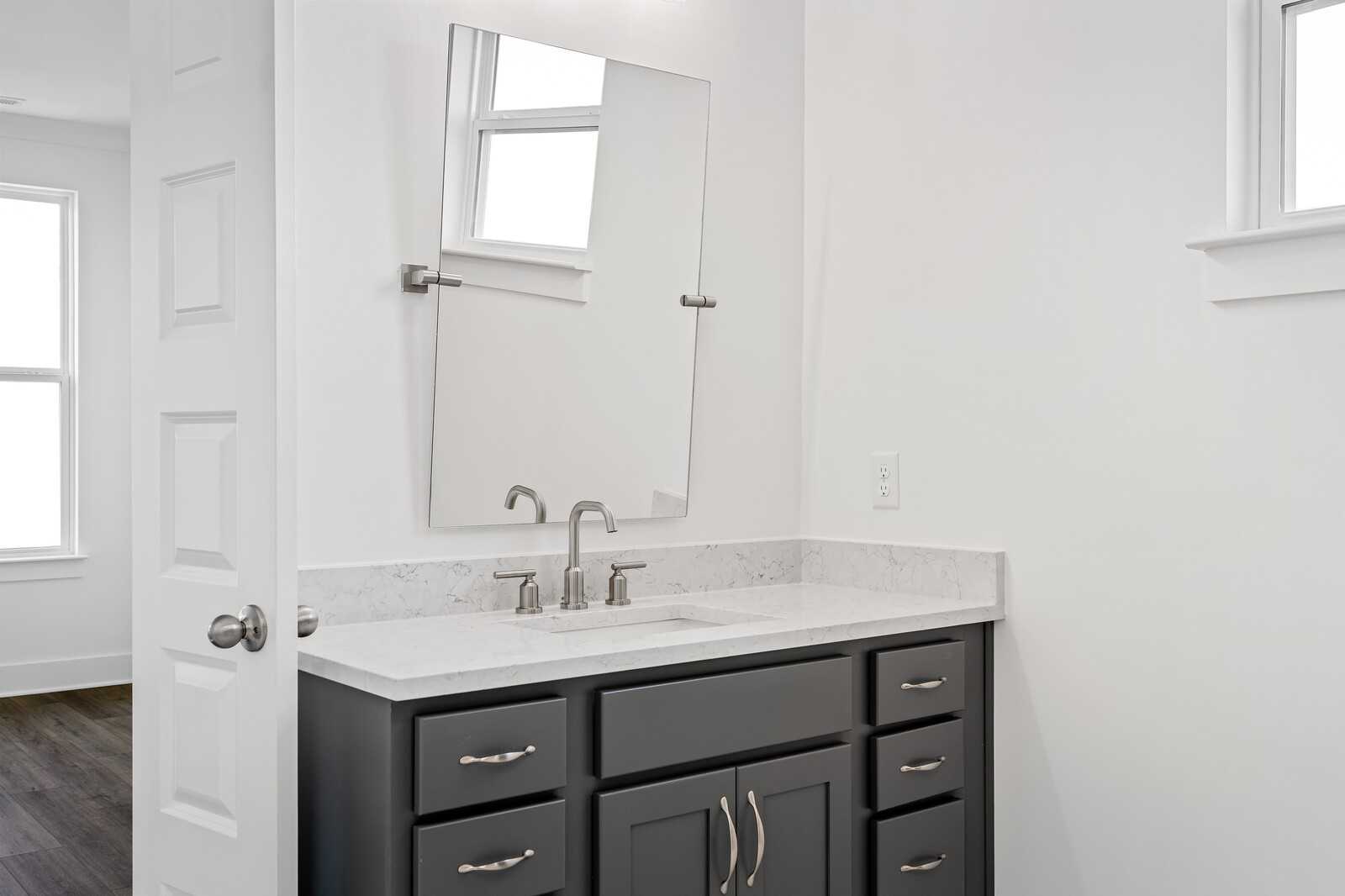 Modern gray double vanity with white quartz countertop, brushed nickel faucet, and large mirror in The Hawkins bathroom, Murfreesboro, TN