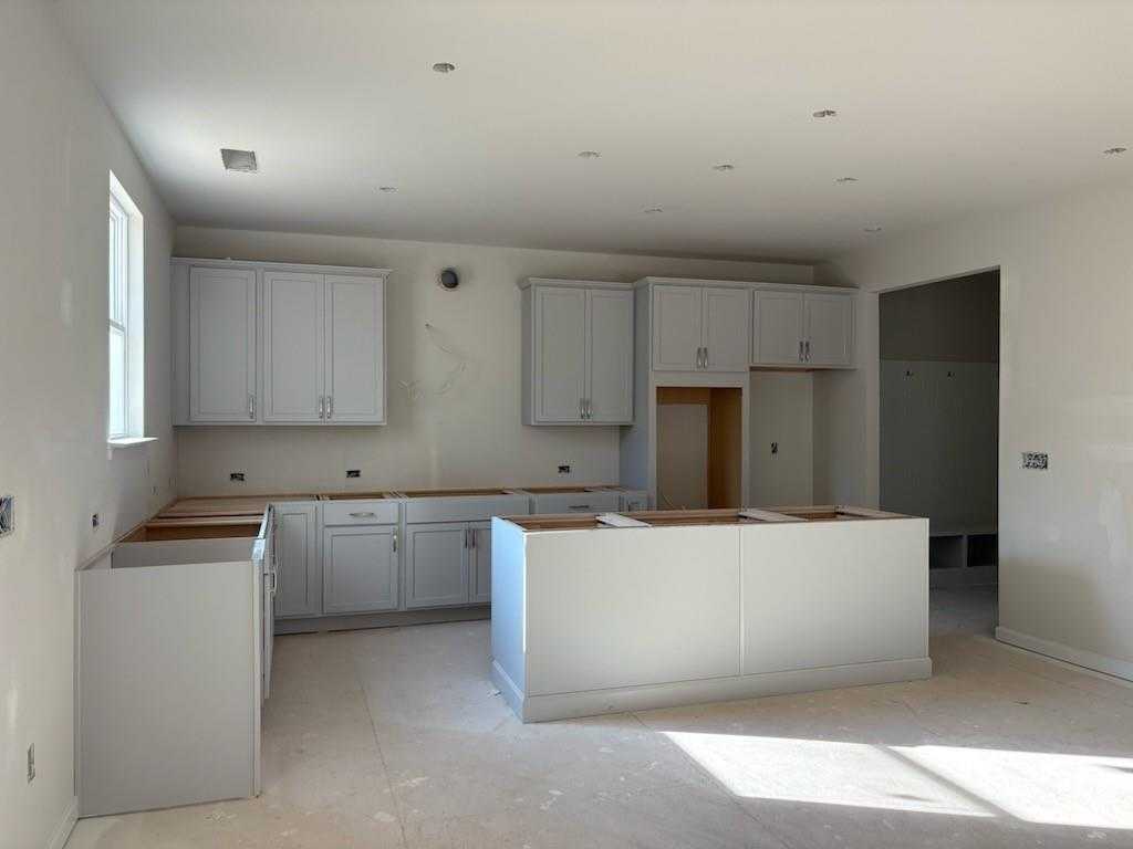 Modern white shaker cabinets and spacious center island in open-concept kitchen of The Hickory A, Davidson Homes, Riverwood, Dallas, GA