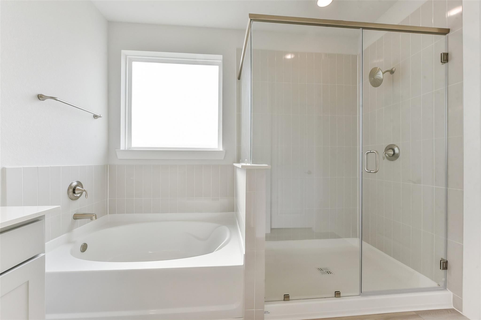 Elegant master bathroom featuring soaking tub and frameless glass shower in Davidson Homes The Edward A, Lago Mar, Texas City