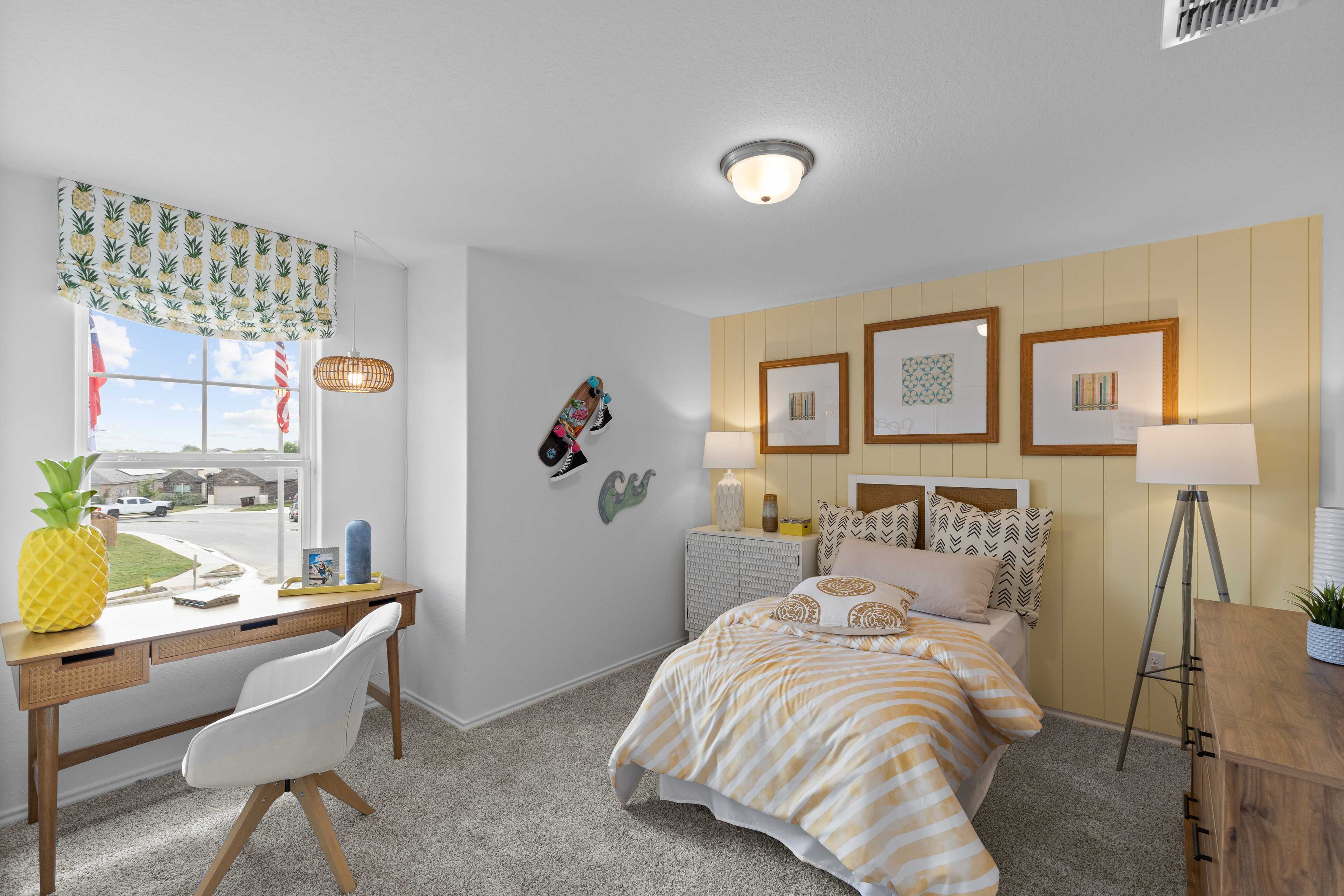 Vibrant kids bedroom at Horizon Pointe in Converse Texas with striped bed, wooden desk, pineapple plant, and colorful curtains