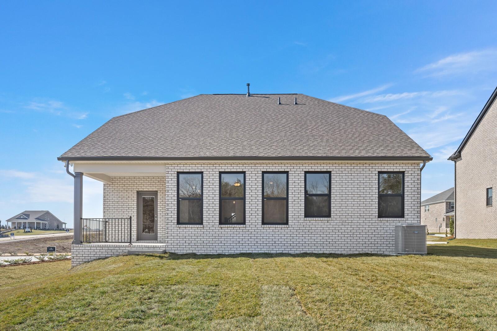 Two-story beige brick home with gabled roof, covered porch, and large black-framed windows in Benders Cove, Mt. Juliet, TN - Davidson Homes The Ash C